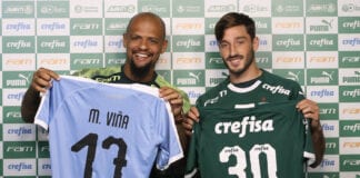 O jogador Felipe Melo (E), da SE Palmeiras, entrega camisa para o mais novo alteta do clube Matías Viña, na Academia de Futebol.