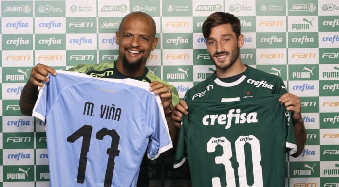 O jogador Felipe Melo (E), da SE Palmeiras, entrega camisa para o mais novo alteta do clube Matías Viña, na Academia de Futebol.