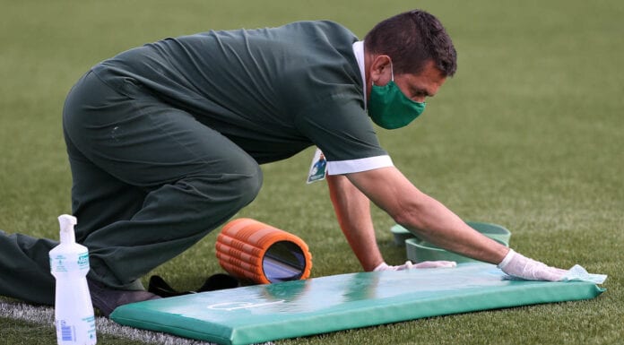 Funcionário do Palmeiras faz limpeza nos colchonetes.