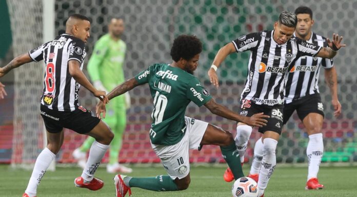 Luiz Adriano disputando a bola contra os jogadores do Atlético-MG(Foto: Cesar Greco / Palmeiras)